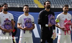 Iran's Hossein Kanaani, Shoja Khalilzadeh, Alireza Beiranvand and Mehdi Taremi hold school bags in memory of the victims of the girls school bombing in Minab, Iran