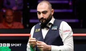 Hossein Vafaei chalking his cue