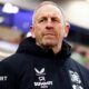Hull FC head coach John Cartwright watches on from the sidelines in a club-issued black coat