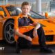 Harry Williams, McLaren's latest Driver Development Programme recruit, in front of a McLaren car.