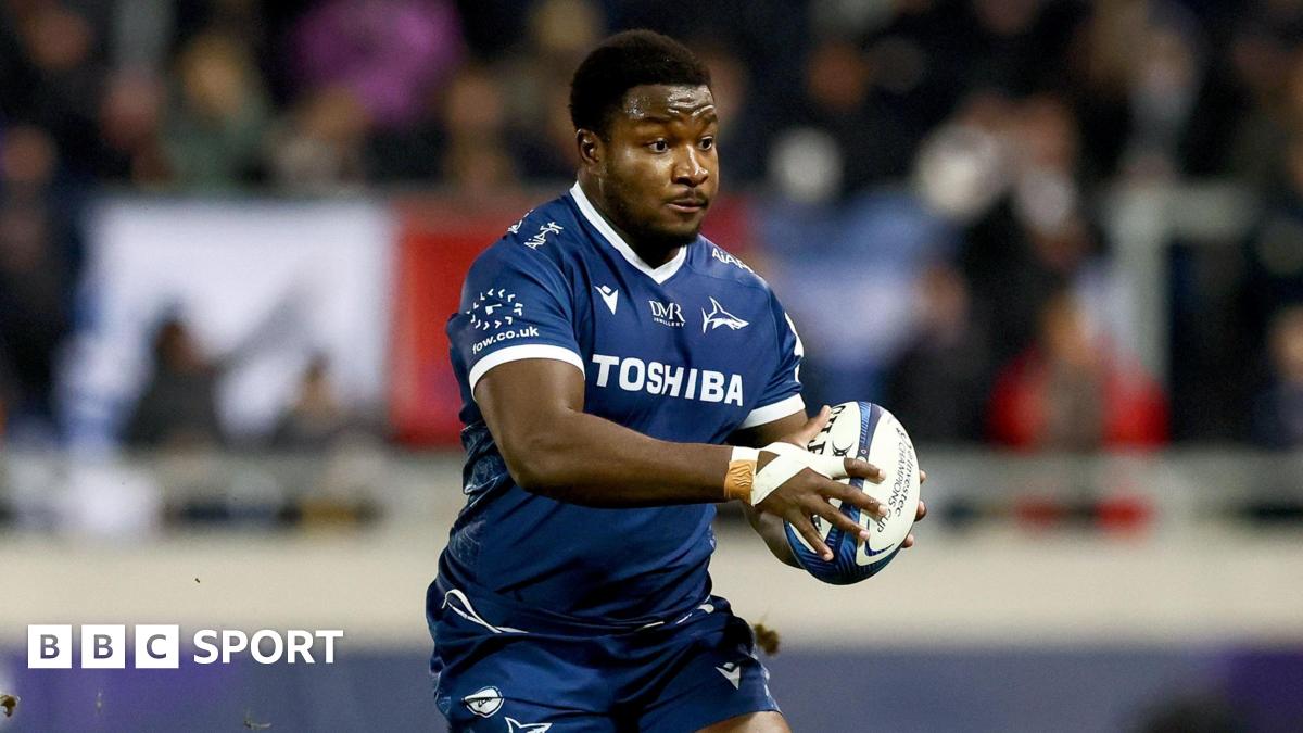 Nathan Jibulu running with the ball to his left side grasped in both hands during a match for Sale