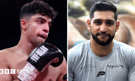 Abdul Khan (left) holds up his hand is wearing a black boxing glove and Amir Khan (right) is wearing a grey t-shirt