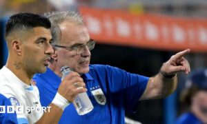 Marcelo Bielsa pointing while standing on the sidelines with Luis Suarez