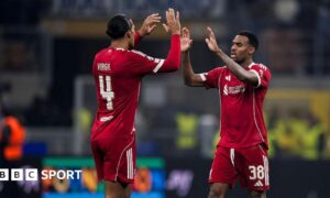 Virgil van Dijk and Ryan Gravenberch high-five each other.
