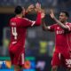 Virgil van Dijk and Ryan Gravenberch high-five each other.