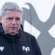 Lance Bradley wearing an Ospreys jacket in front of an Ospreys logo at Brewery Field