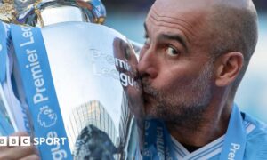 Pep Guardiola kisses the Premier League trophy
