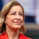 Close up of Chris Evert wearing a red jacket and staring slightly up to the sky
