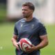 Leigh Halfpenny holds a ball while watching Wales training