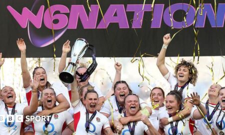 Meg Jones lifts the Women's Six Nations trophy surrounded by team-mates with tickertape falling down