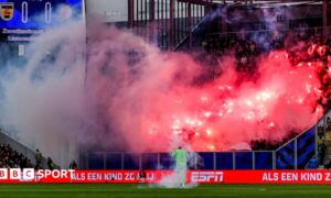 Feyenoord supporters set off fireworks and throw them onto the pitch near goalkeeper Tjark Ernst during their match at SC Cambuur