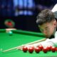 Liam Davies, wearing a white shirt and black waistcoat, leans over the table to play a shot at the Wuhan Open in August