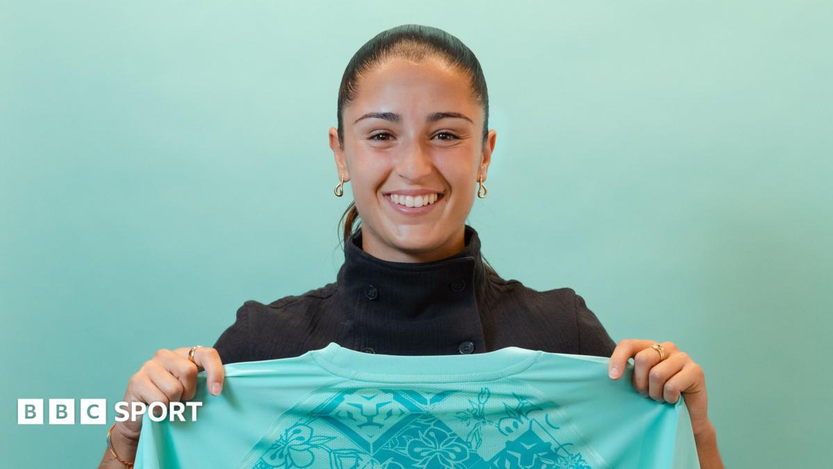A smiling Jana Fernandez holds a London City shirt